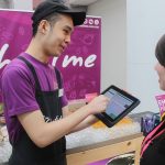 Chatime's event coordinator Wing taking customer orders using the new POS system running on Microsoft Windows and Azure at an event booth.