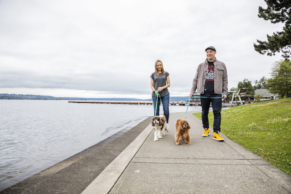 a man and a woman walking a dog together