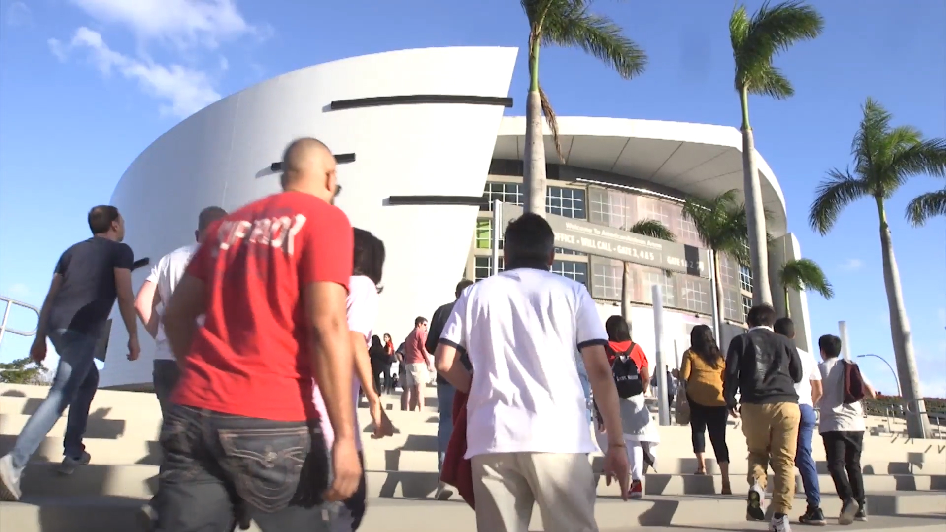 A picture of people walking towards a stadium