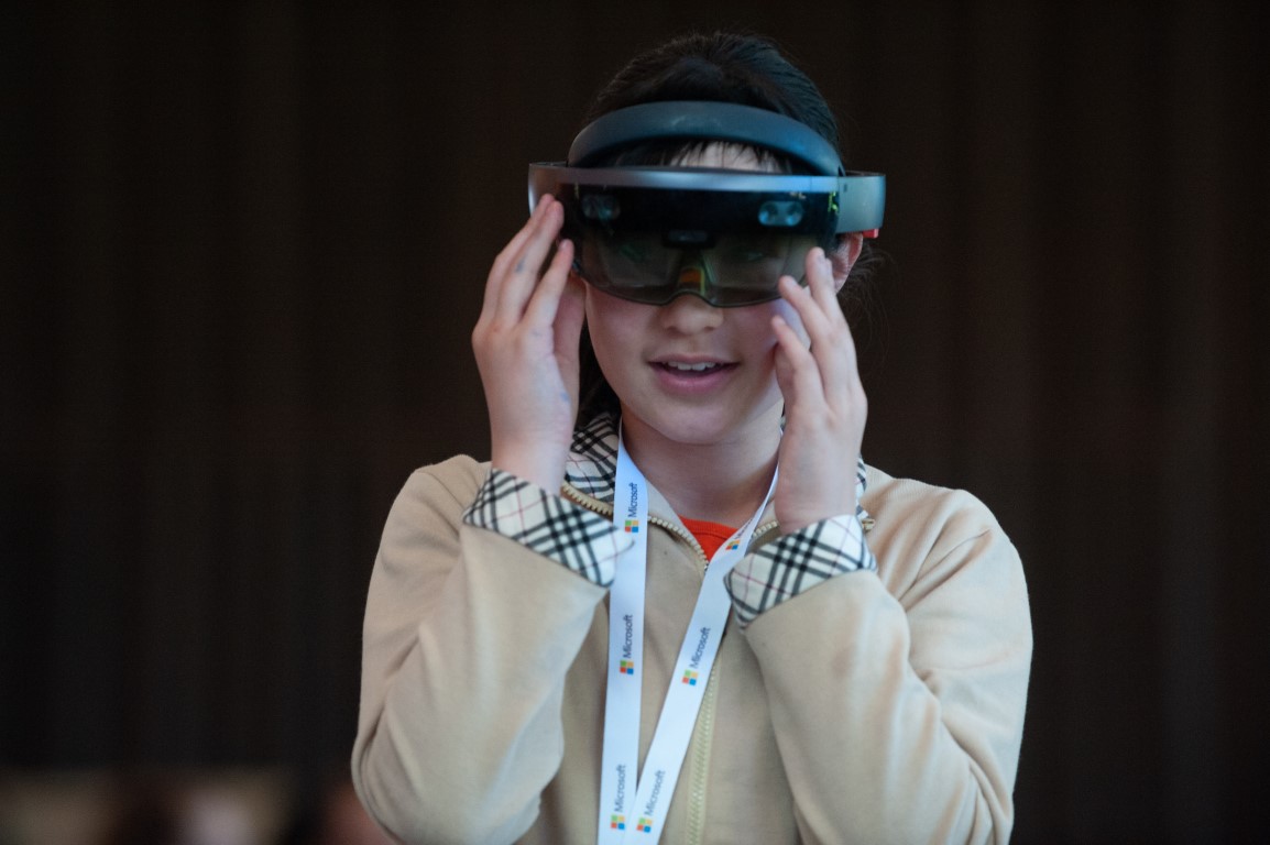 Young girl trying out the mixed reality HoloLens, broadening her exposure to STEAM at DigiGirlz