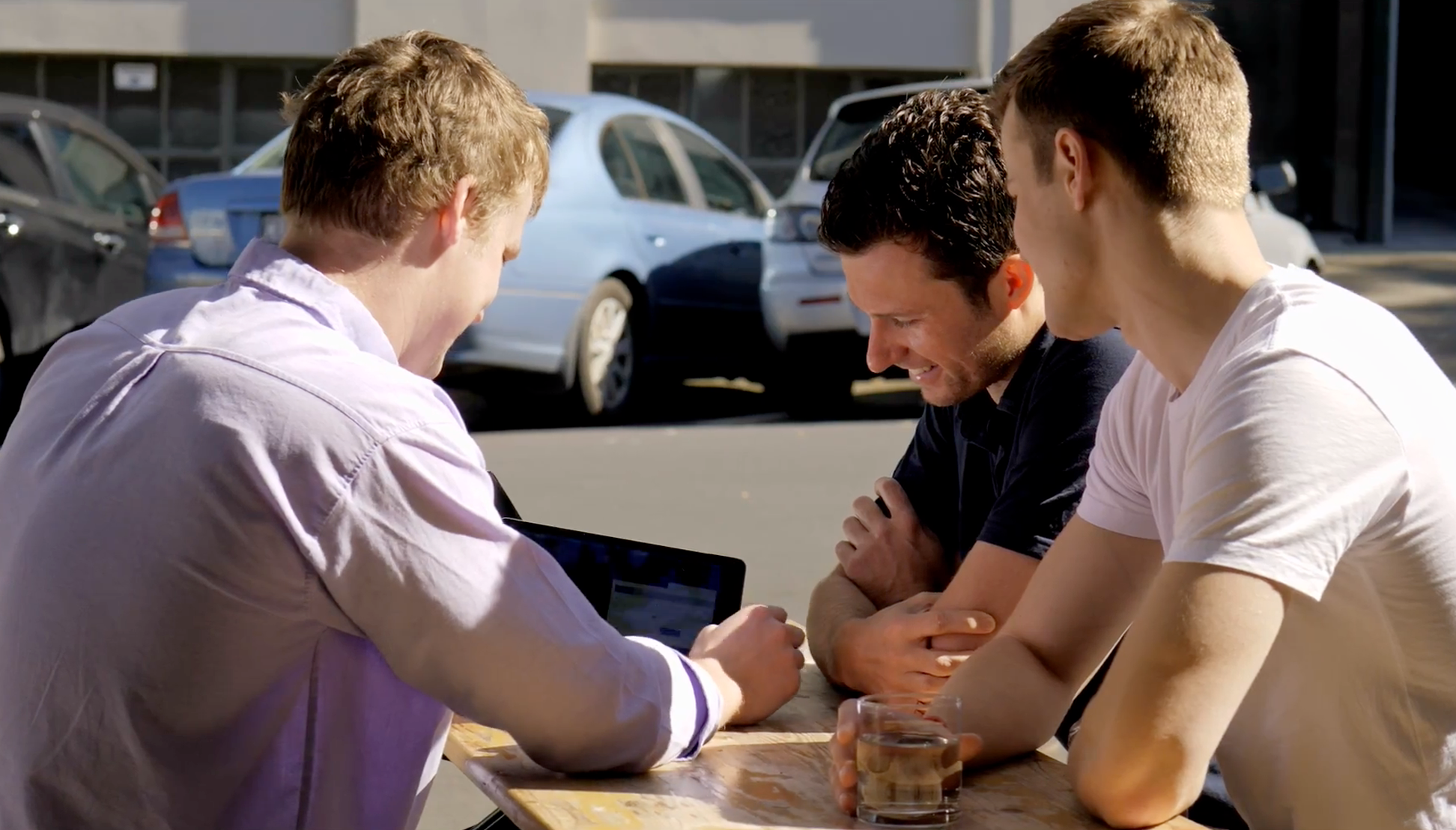 The Instillery Team Huddling around device