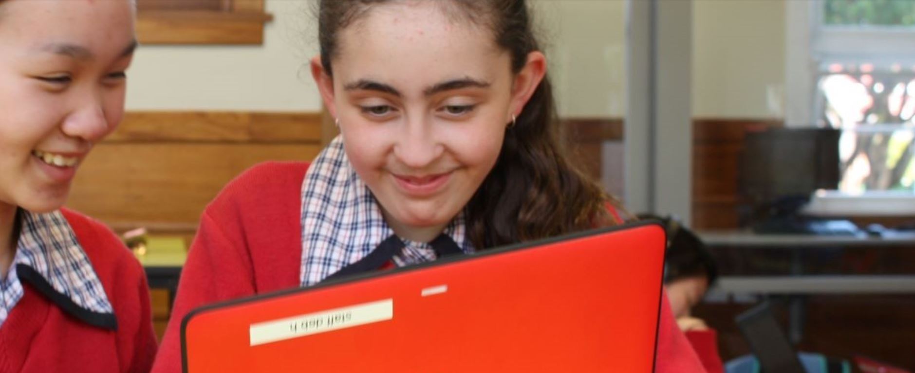 Girls enjoying using their devices at school