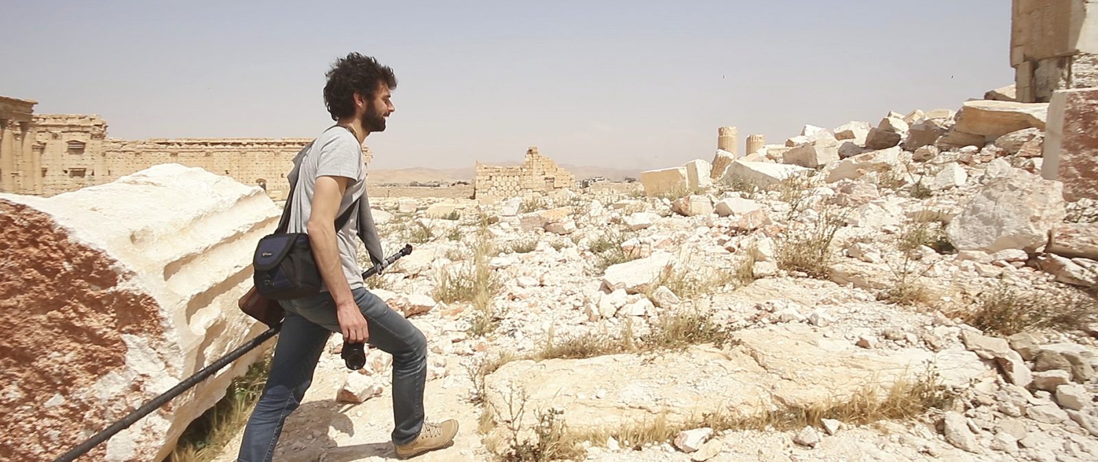 A man climbing up ruins of a historic landmark