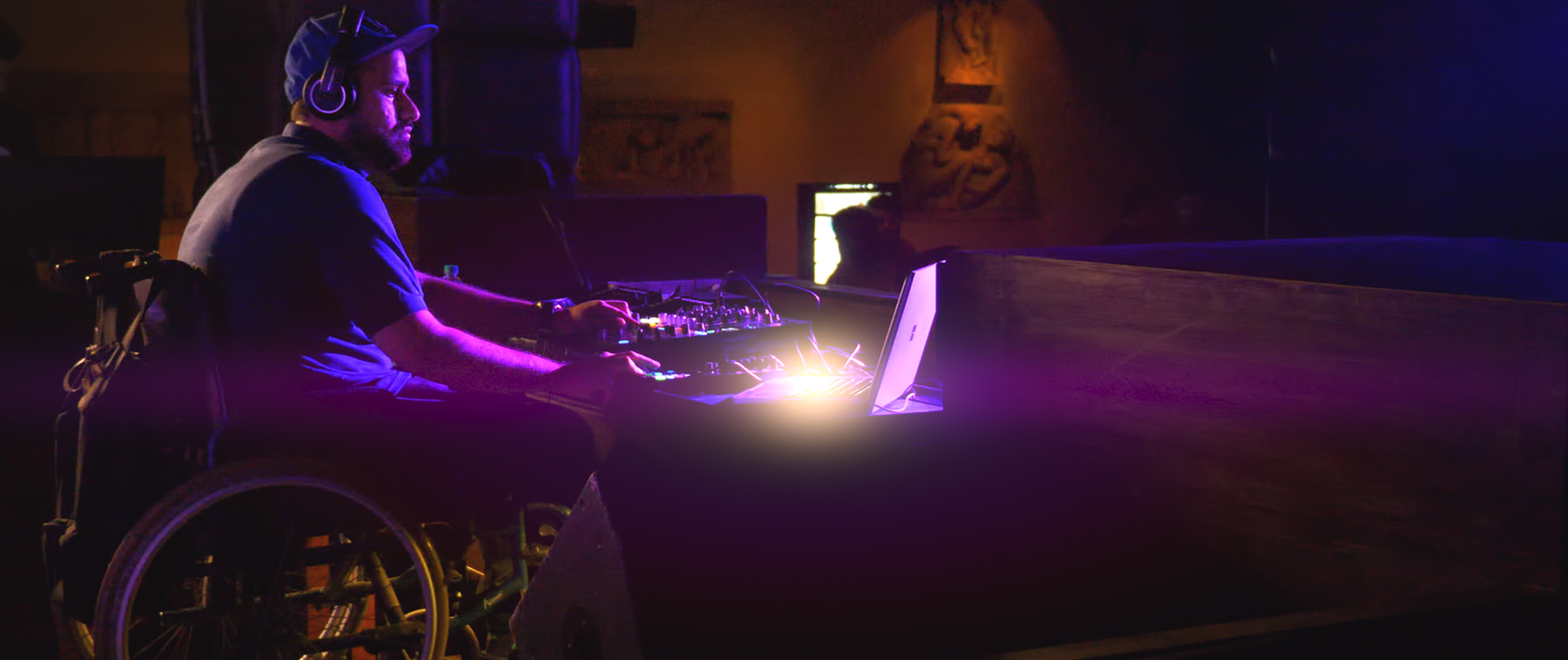Varun Khullar on a wheelchair on the DJ console with the Surface Book 2