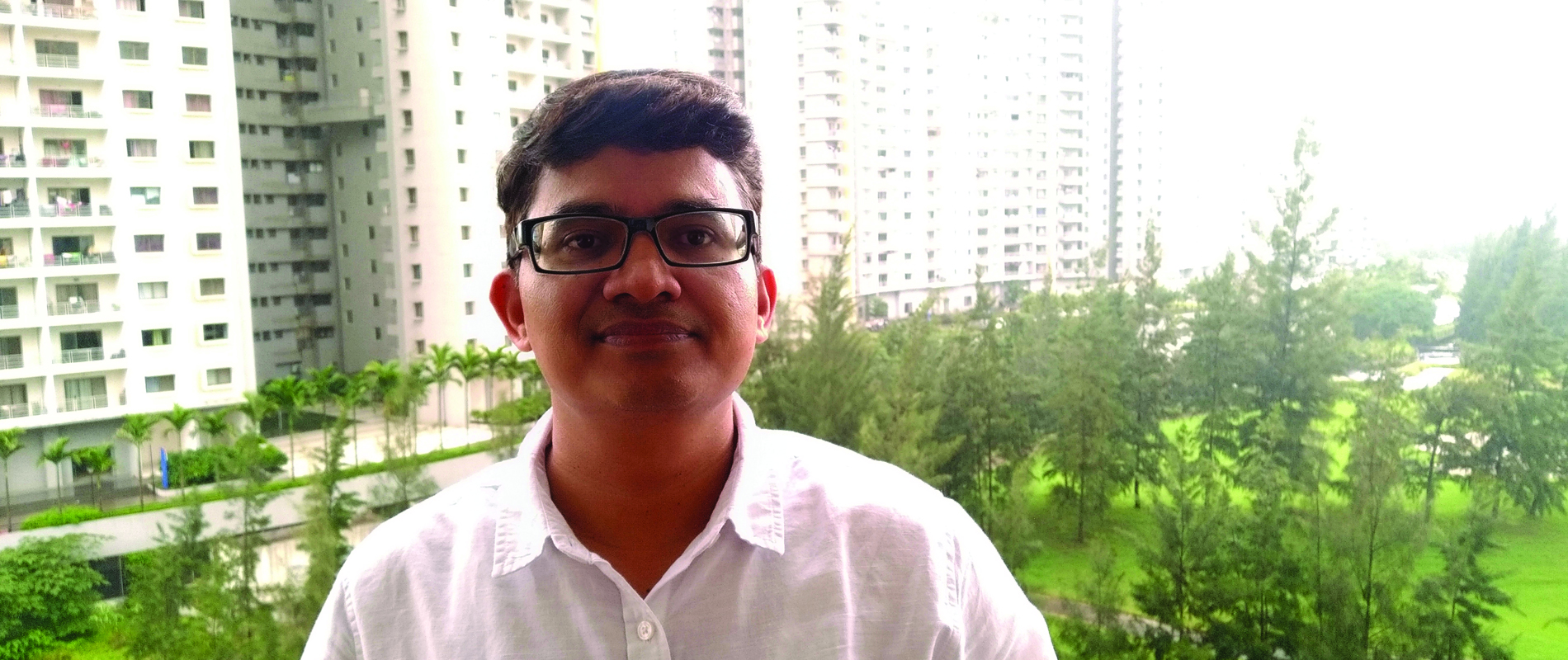 a man standing with buildings in the background