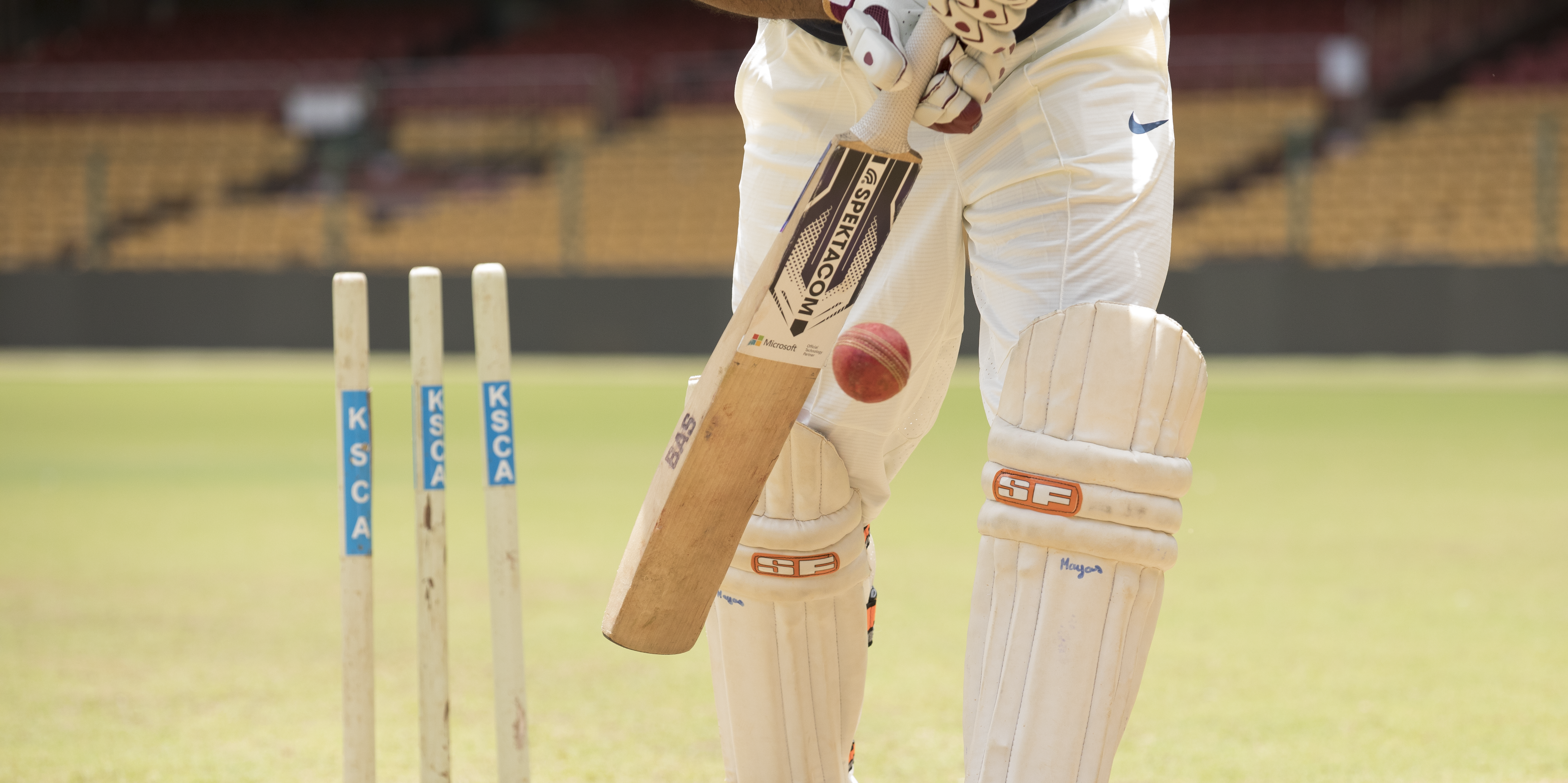 A cricket batsman hitting a ball