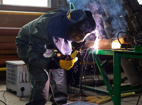 An industrial worker using welding equipment