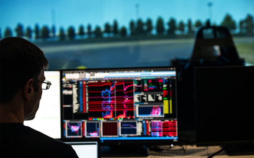 A technician examines performance test results in racing stimulator of Formula One manufacturing plant.