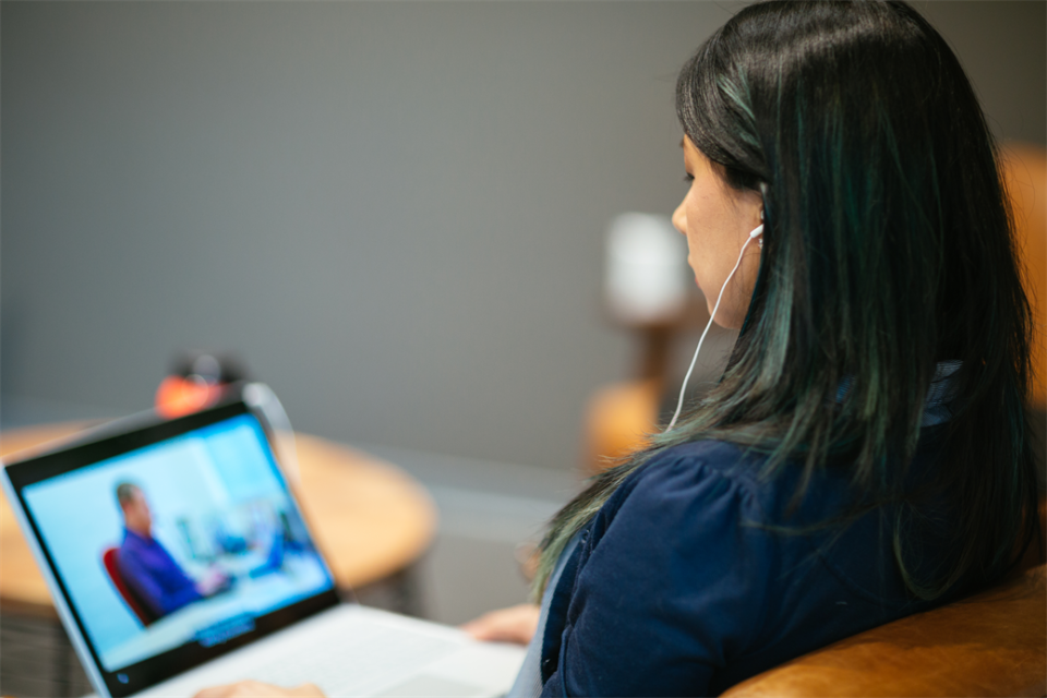 A woman watching a video with captions on her laptop