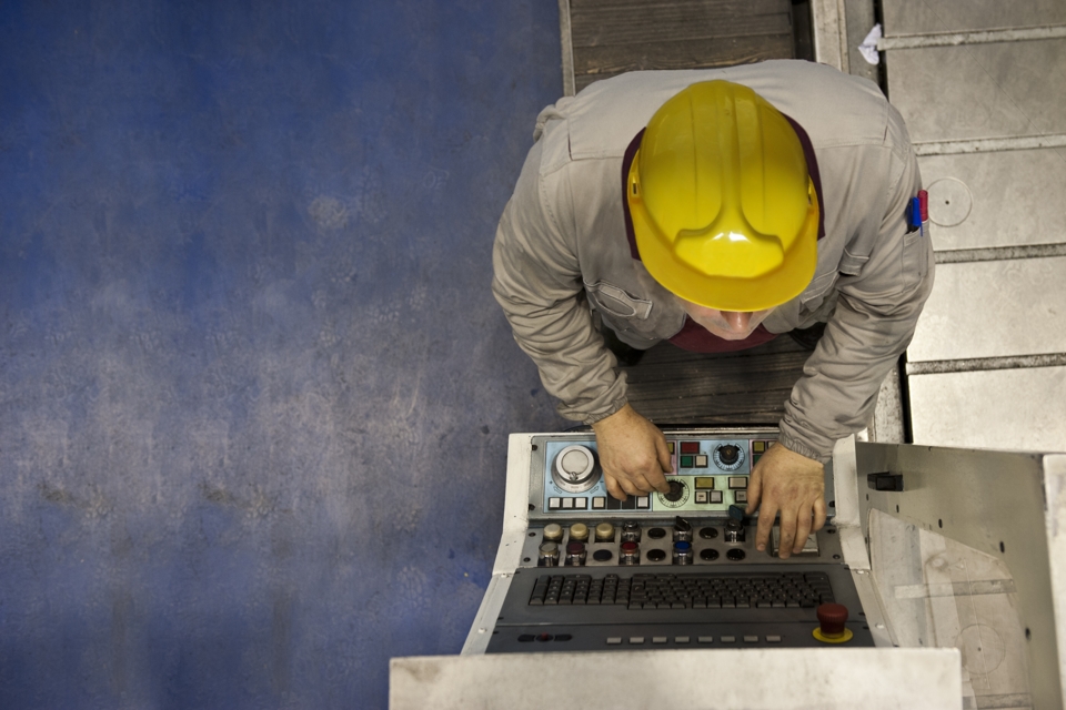 An image showing a factory worker working on a console
