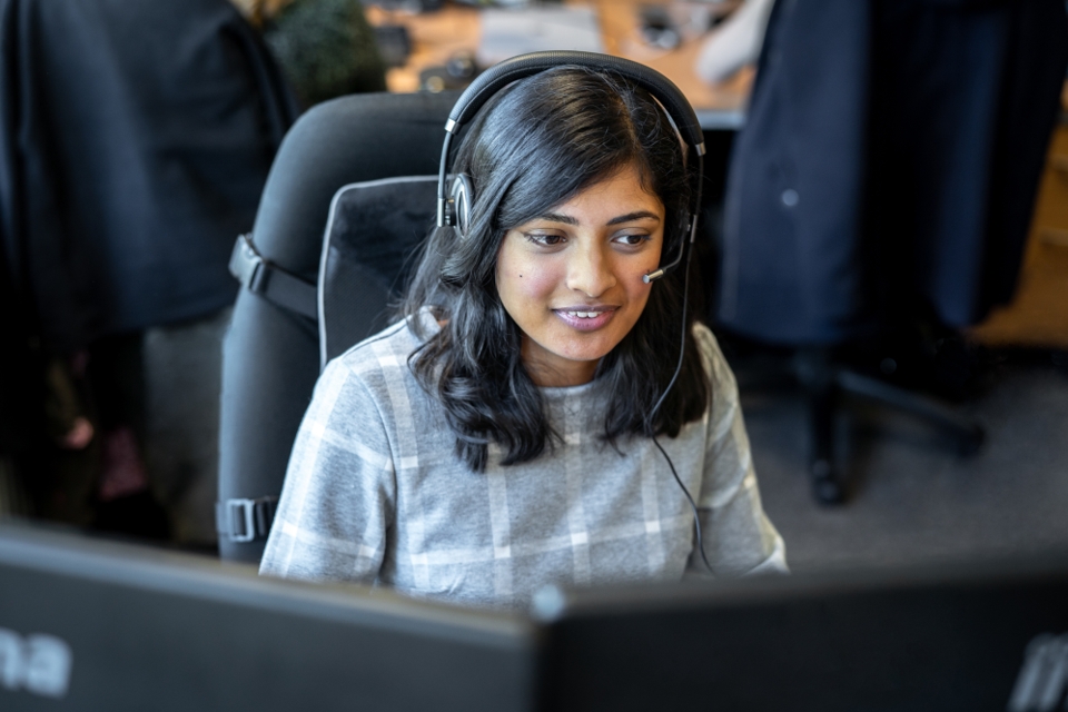 Photo of a girl wearing headphones and working on a computer
