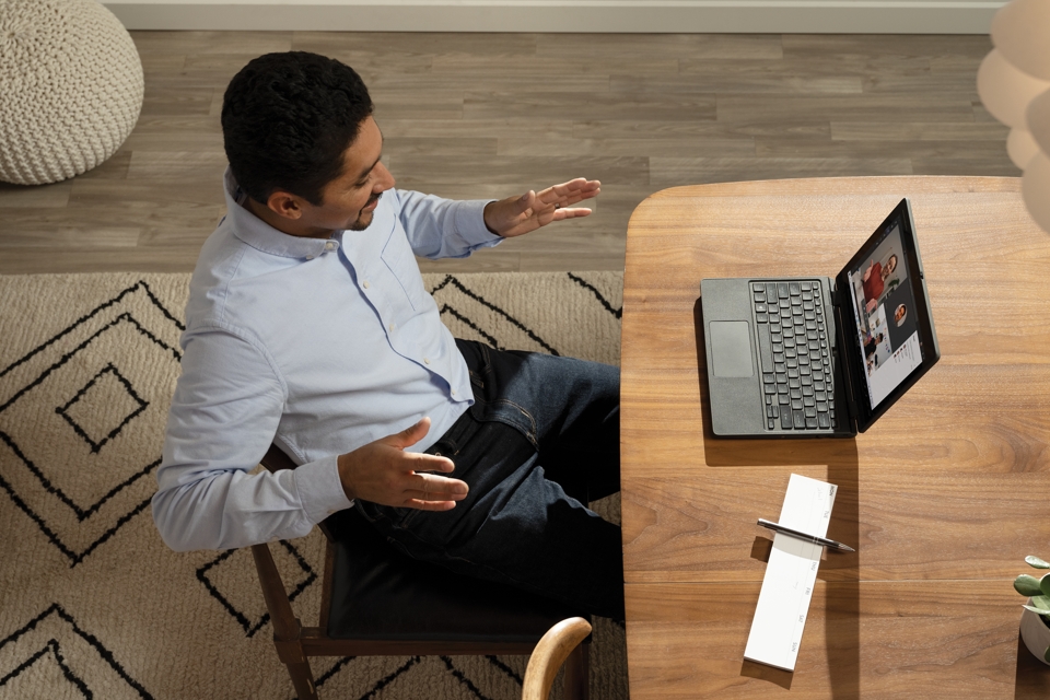 A photo of a man in a video meeting on his laptop