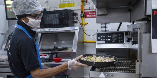 Photo of a man preparing pizza in a kitchen