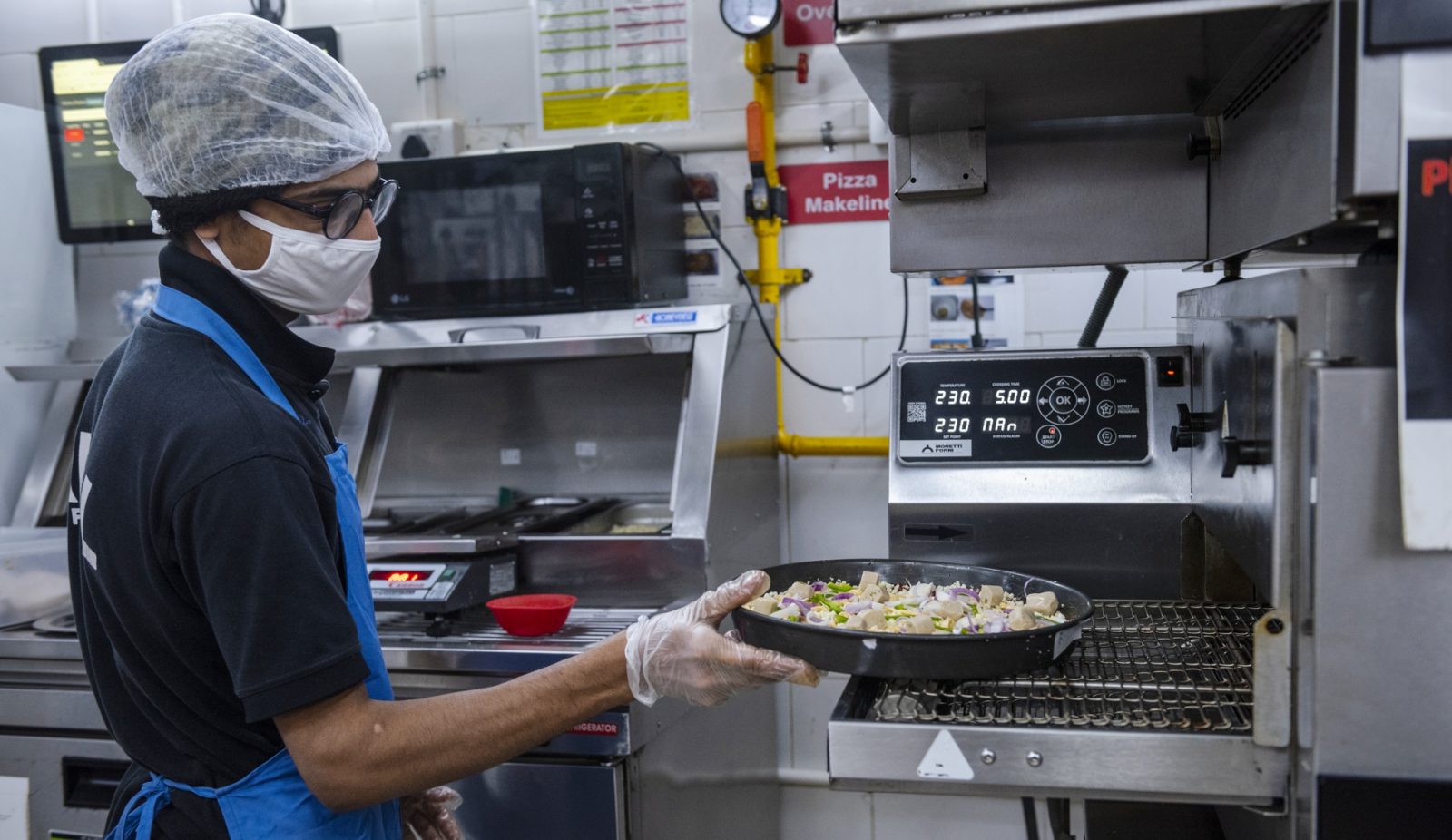Photo of a man making pizza in a kitchen