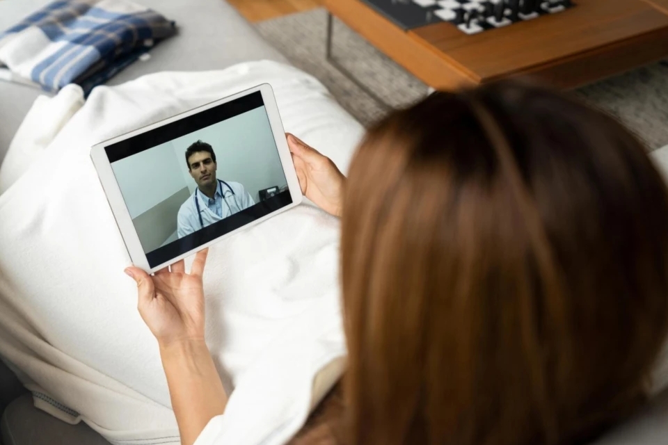Photo of a woman virtually consulting a doctor on her tablet