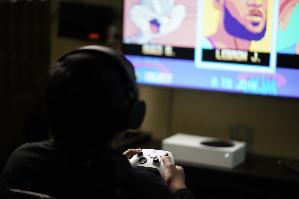 an over the shoulder shot of a boy playing an xbox game