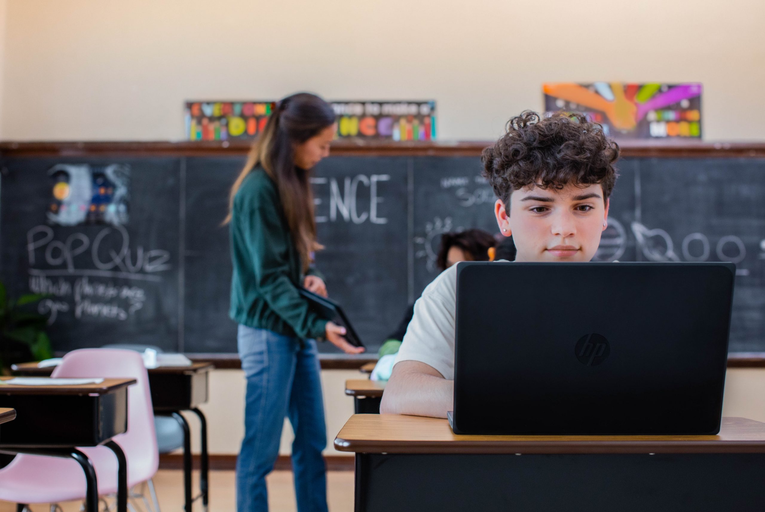 kid in a classroom studying on a laptop