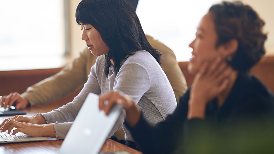Two women working with their laptops