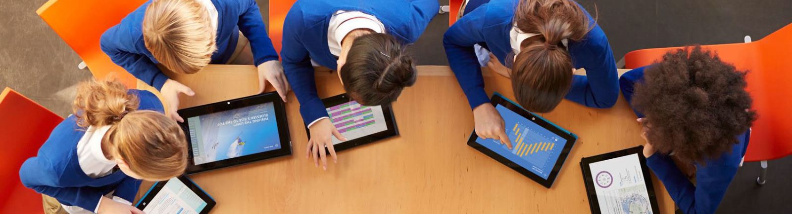 Вид сверху: школьники склонились над планшетами