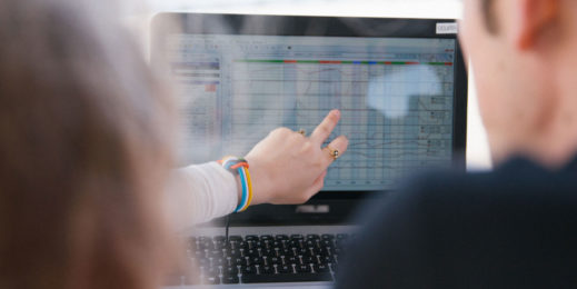 женская рука показывает что-т на графике, на экране ПК