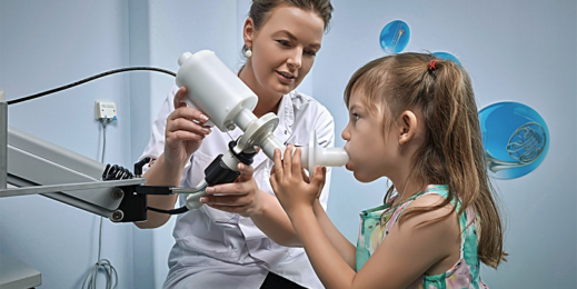 Женщина-врач и девочка, делают процедуры с аппаратом для дыхания