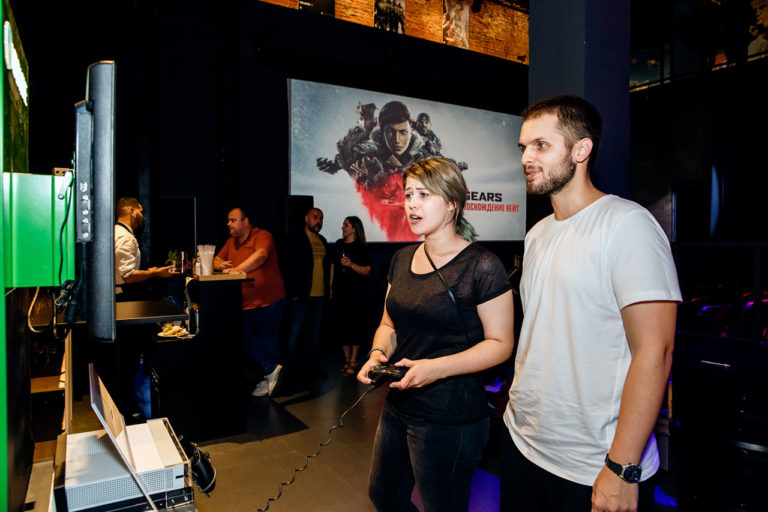 Девушка играет на консоли. Репортаж с мероприятия, посвященного страту продаж игры Gears 5