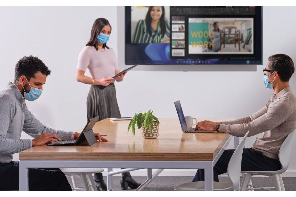 Сотрудники в офисе, девушка стоит с планшетом