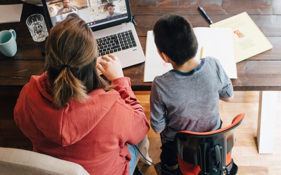 Женщина и мальчик склонились над ноутбуком. Вид сверху