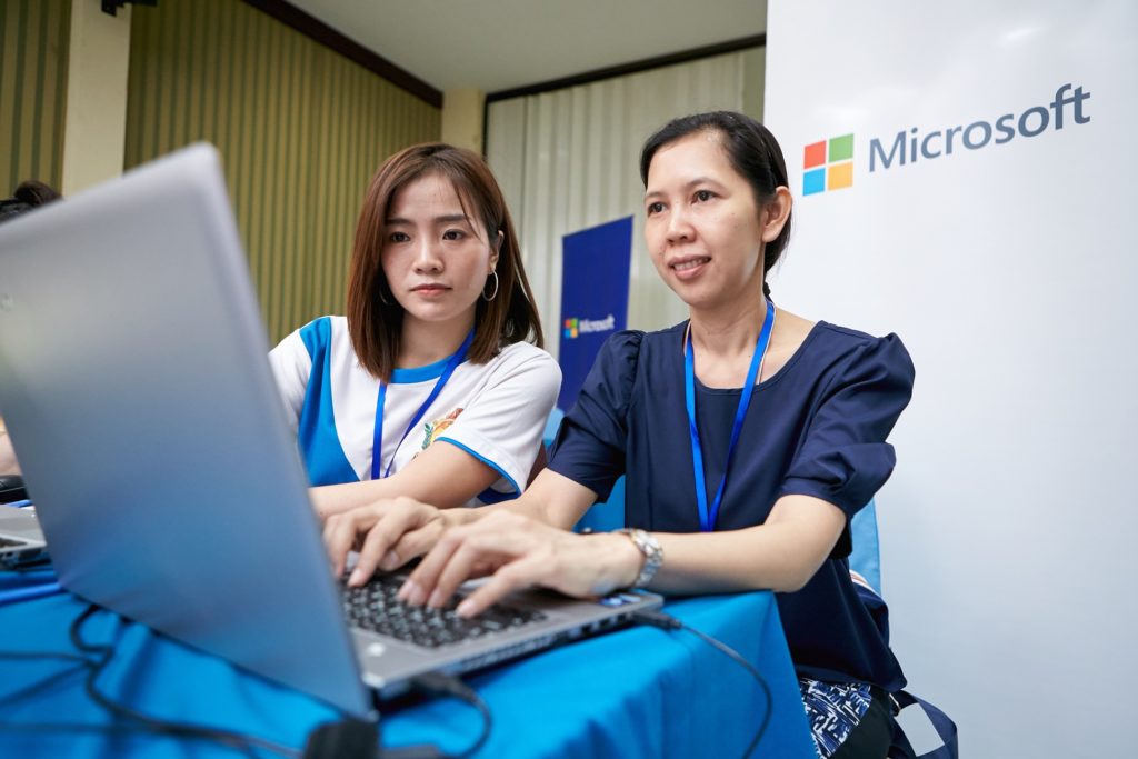 Two women working together on one laptop