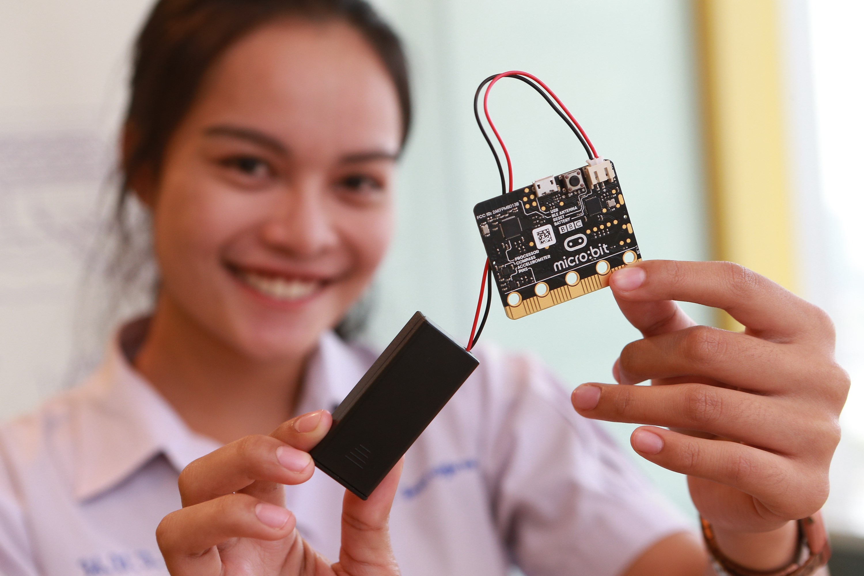 Smiling woman holding circuit board