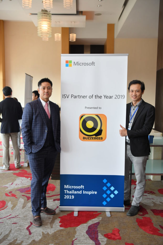 Executive and award in front of signage