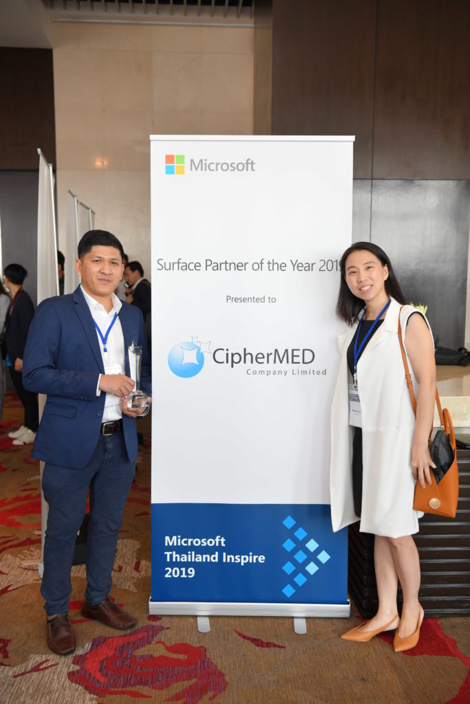 Executives and award in front of signage