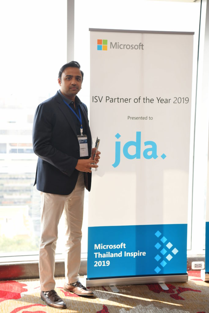 Executive and award in front of signage
