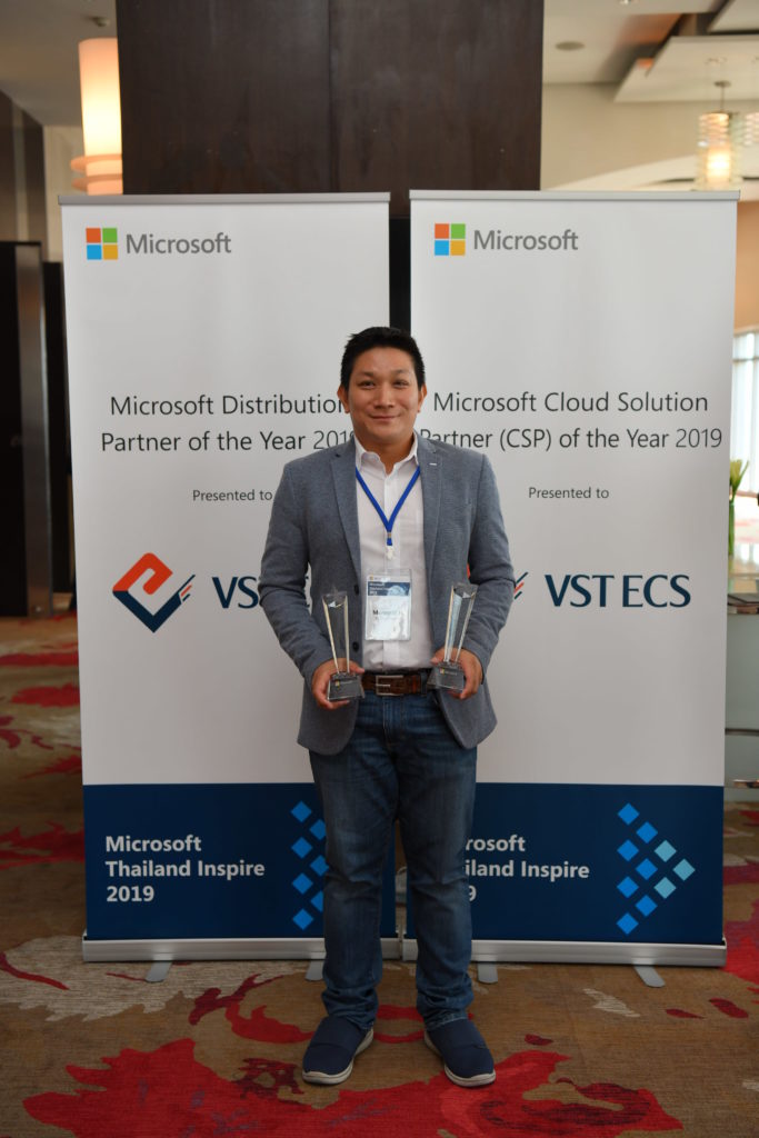 Executive and awards in front of signage