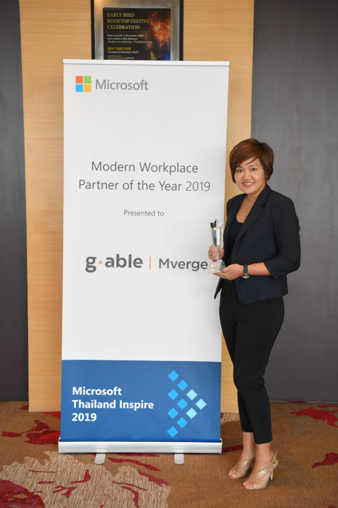 Executive and award in front of signage