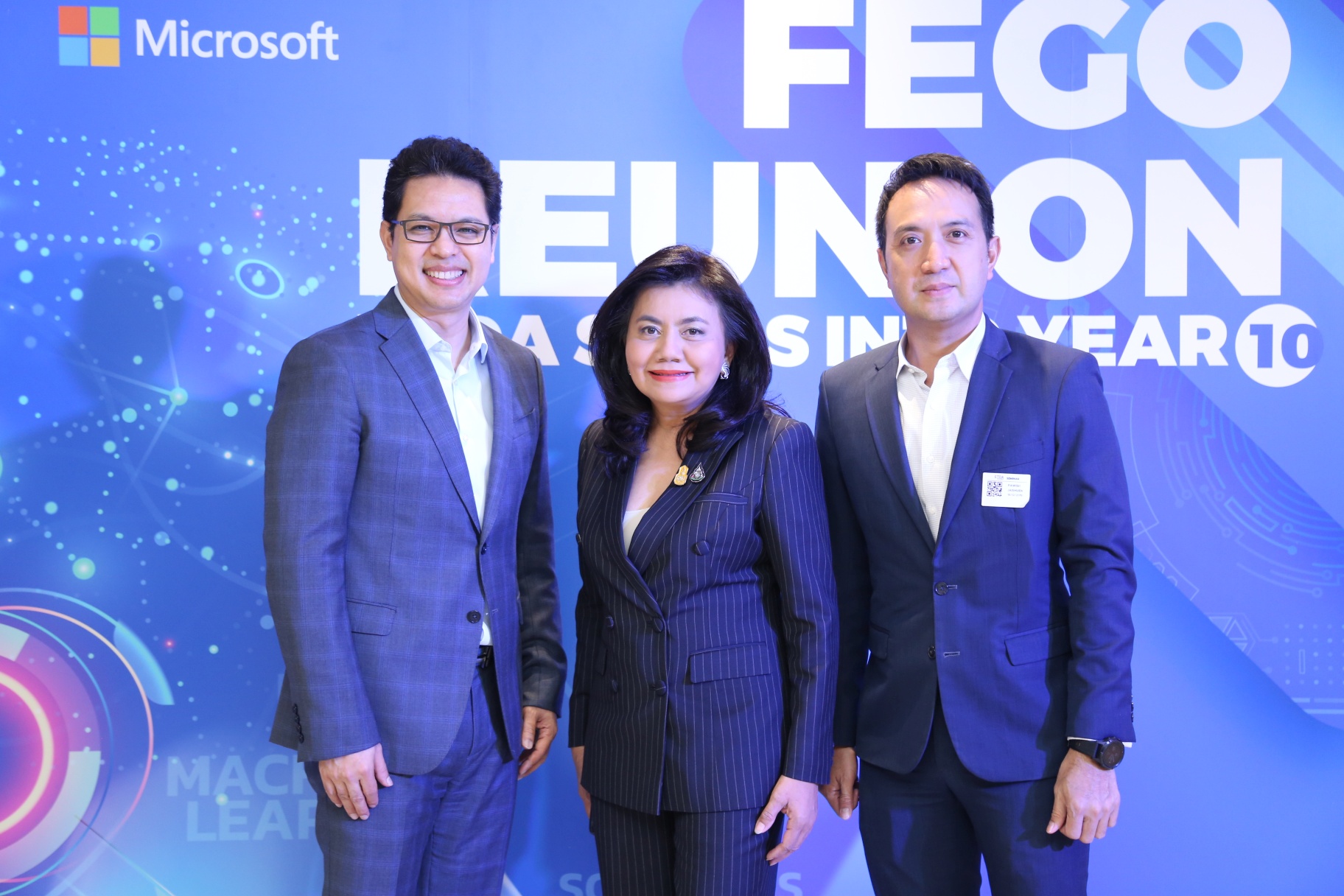 Executives in front of blue backdrop