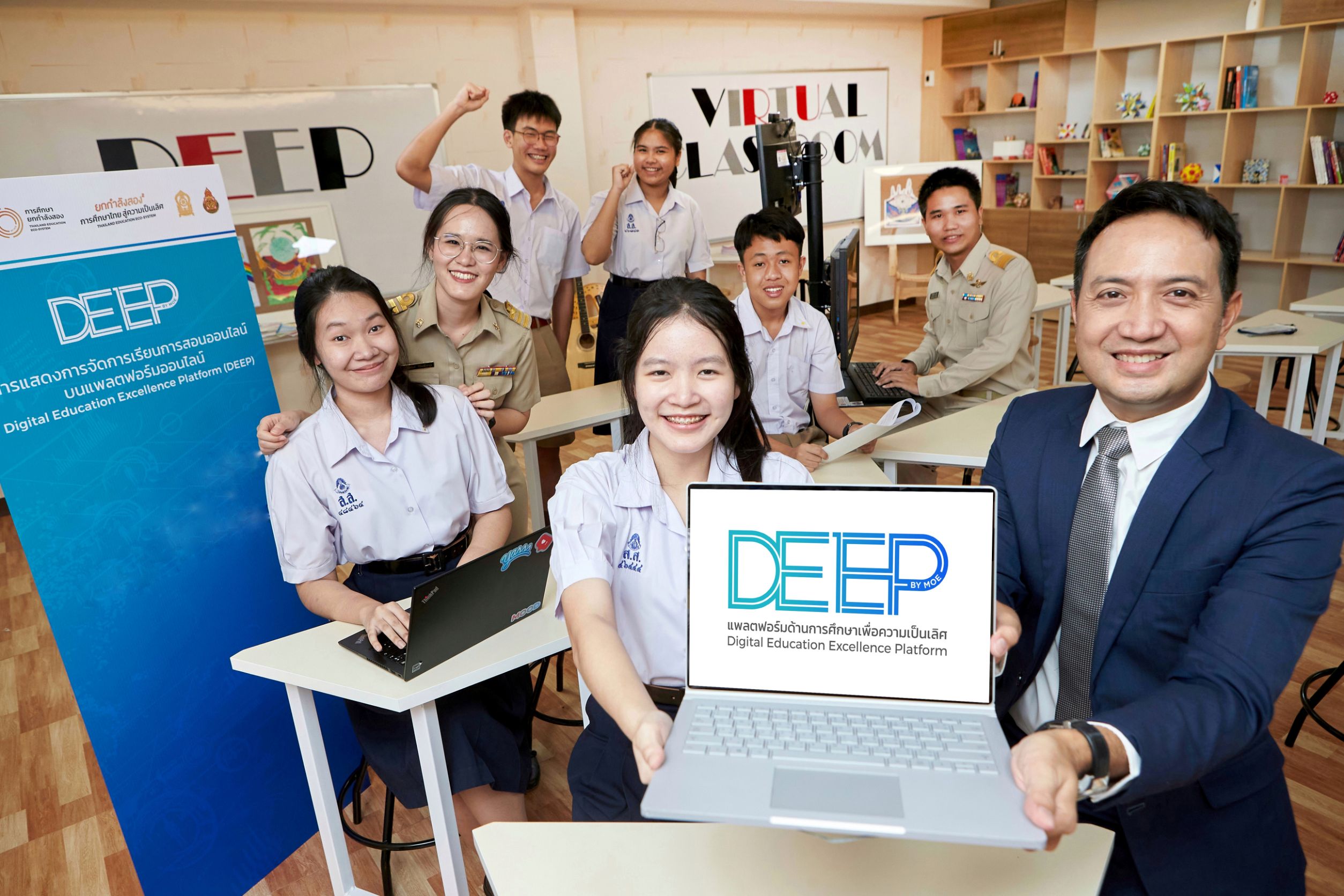 Man in suit jacket and student holds laptop with DEEP logo