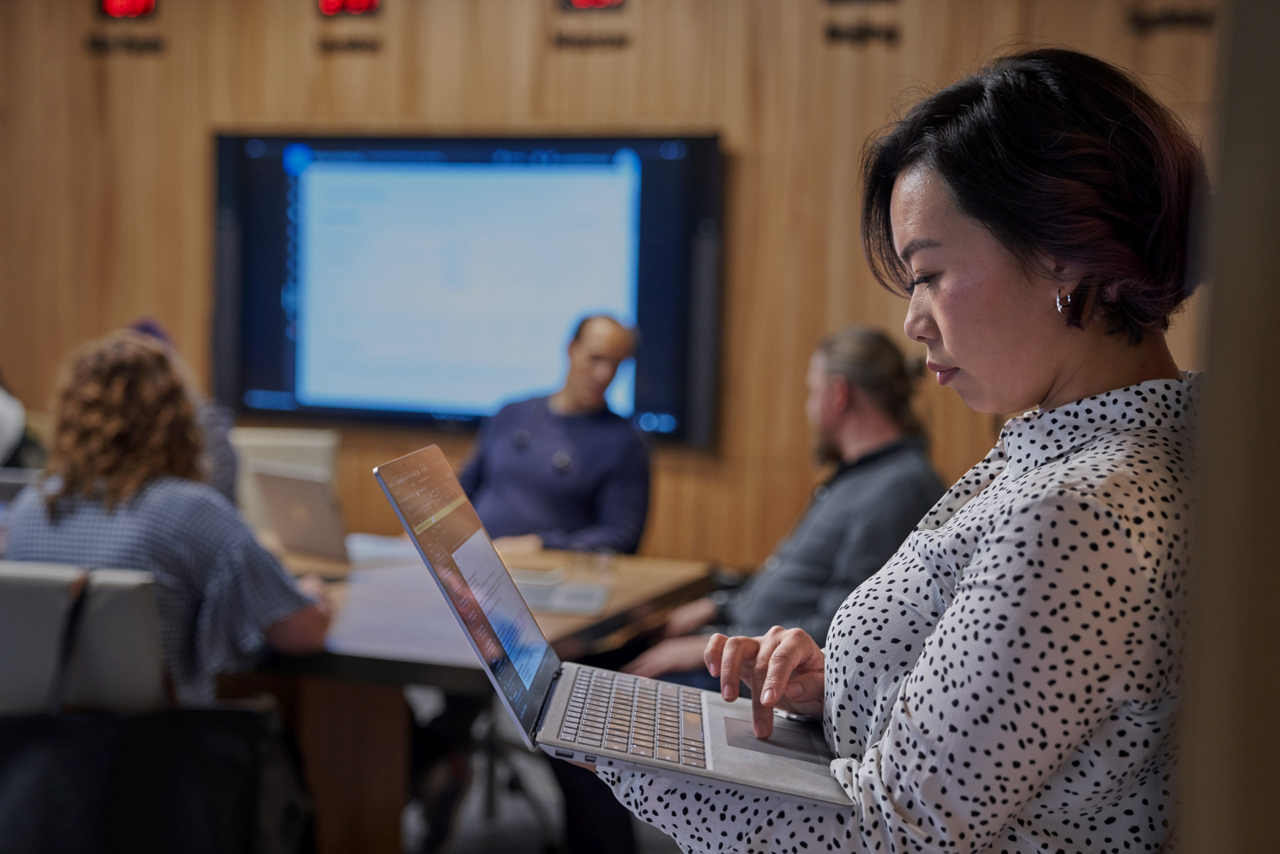 Woman using a laptop just outside meeting room