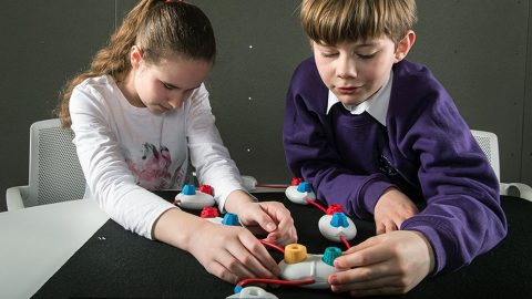 Lexy Ryan and Theo Holroyd handle physical pods on a table