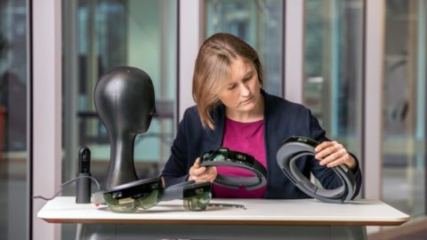 Woman handling HoloLens devices at a table