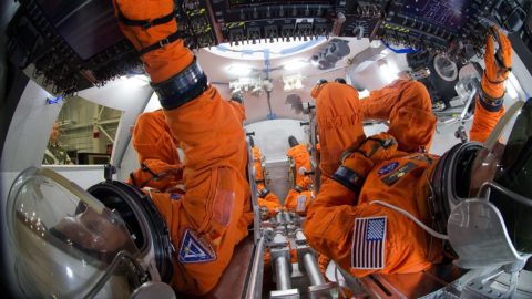 Suited personnel in a Orion mockup capsule