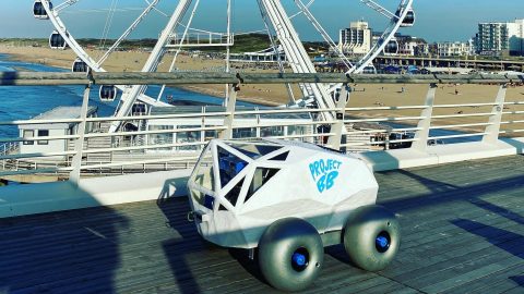 BeachBot sits on a raised boardwalk at Scheveningen Beach with the Ferris wheel in the background