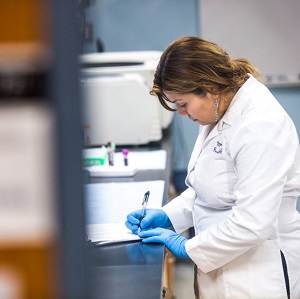 woman in lab coat filling out paper work