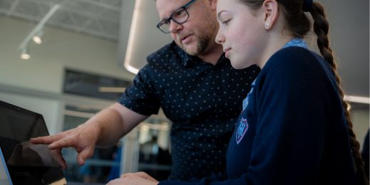 Enseignant aidant un élève qui utilise EdChat sur un ordinateur.