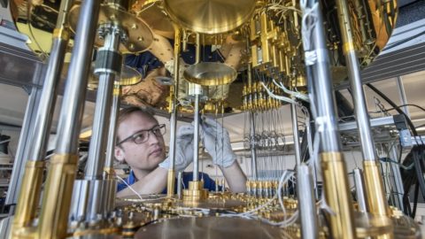 Man working on a quantum computer. Lots of metal and gold color.
