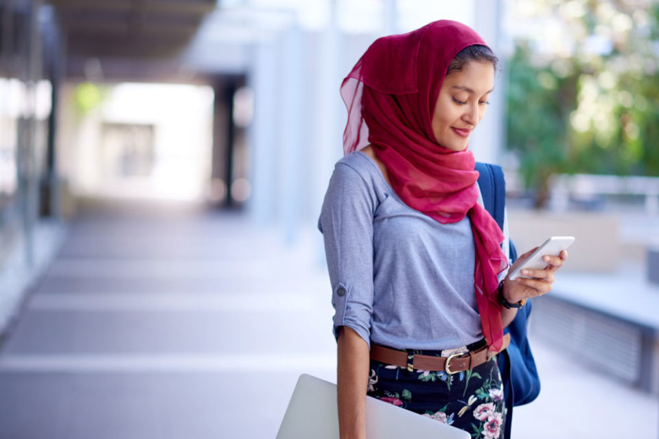 طالبة تستخدم الهاتف الخليوي في الحرم الجامعي