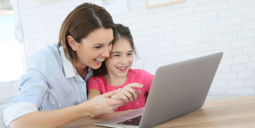 تكمل الأم وابنتها مهام المدرسة عبر الإنترنت من خلال جهاز كمبيوتر محمول.