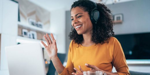 Young female profession talks animatedly on a conference call as she works from home.