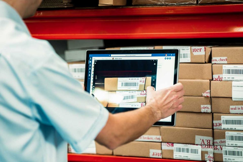 Employee uses a tablet to scan in product barcodes of company stock