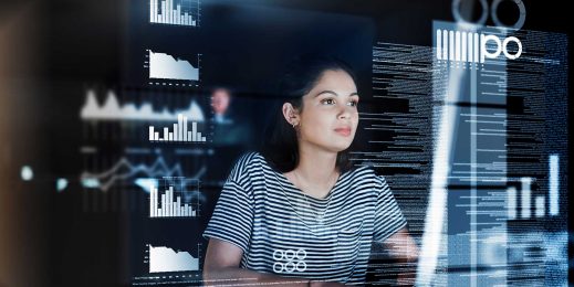 A young female developer focuses intently on the on-screen data in front of her.